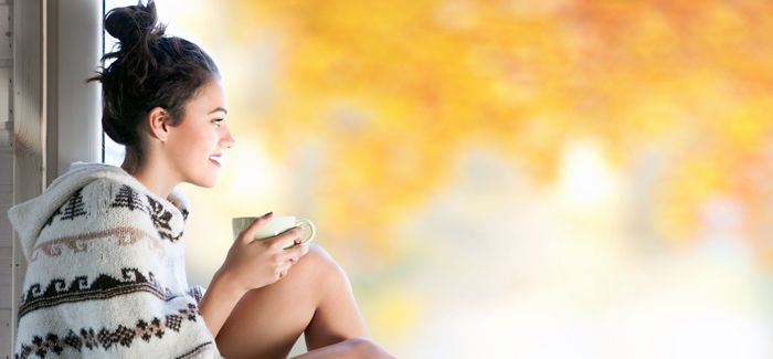 Young beautiful brunette woman with cup of coffee wearing knitt